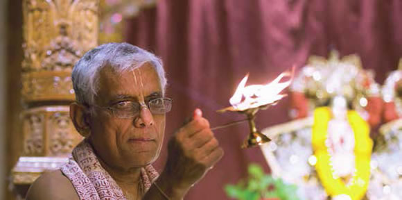 Dvarakanatha Dasa, presente nel tempio dal 1975, offre una lampada a Sri Sri Radha-Nila-Madhava (foto sotto) durante la cerimonia del mattino.