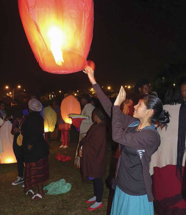 Una giovane devota libera nell’aria una lanterna votiva al festival delle lanterne, che si tiene al tempio durante il ritiro annuale della gioventù.