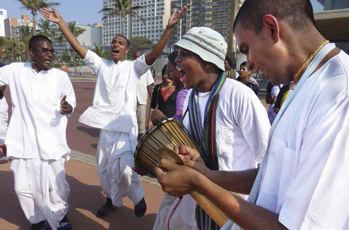  I devoti danzano durante un kirtan nelle strade della città accompagnandosi con strumenti tradizionali.