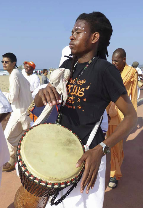 Il nuovo arrivato Fortune Ndlovu suona il tradizionale jembe durante un kirtan sul lungomare di Durban.
